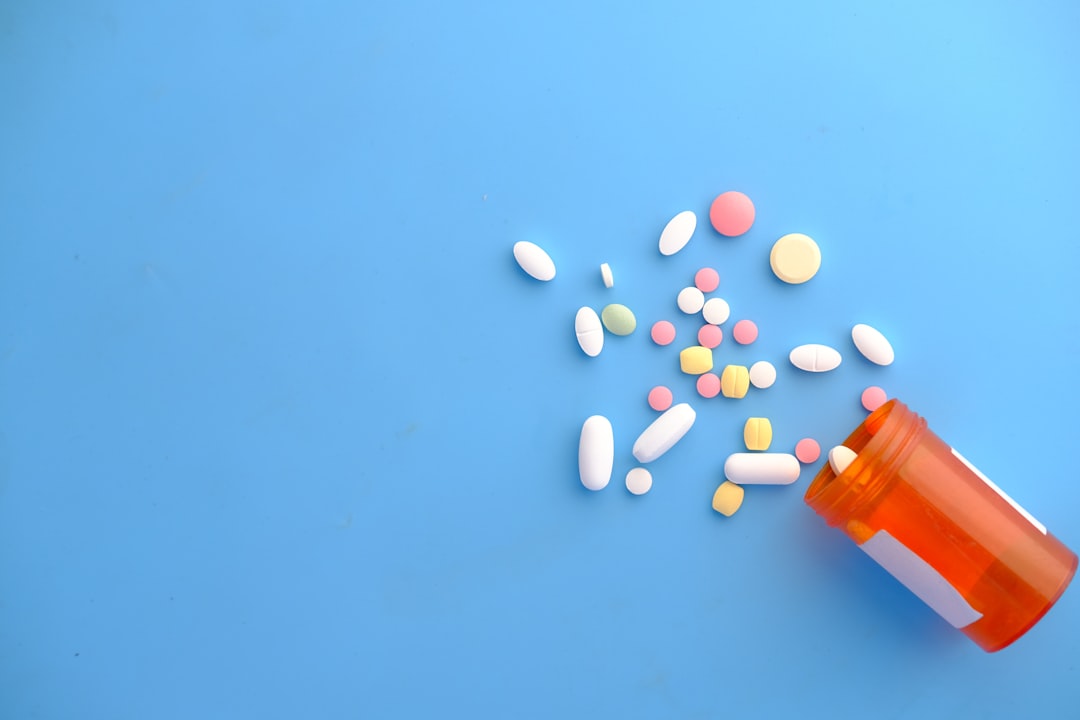 Prescription pill bottle and tablets representing medications that can raise uric acid.